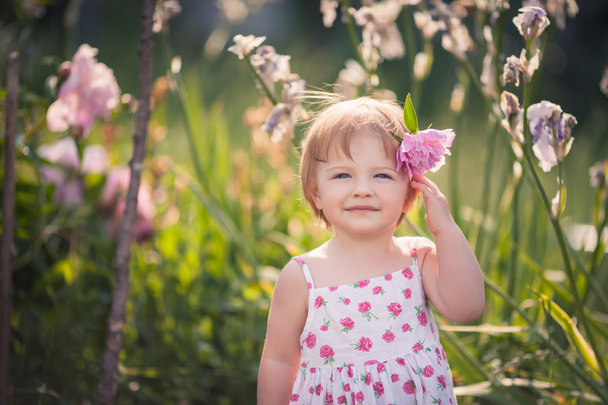 Kislány a nyári kertben fényes virágok - Fotó, kép
