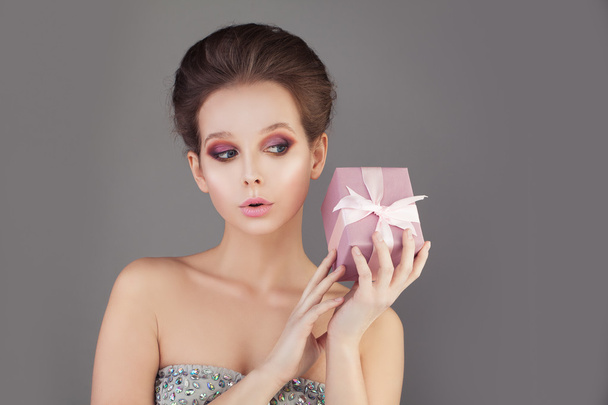 Preciosa modelo de moda mujer sosteniendo regalo
 - Foto, Imagen