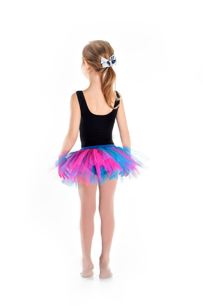 Little Ballerina in tutu on a white studio background. Studying dance is busy doing the exercises. - Foto, afbeelding