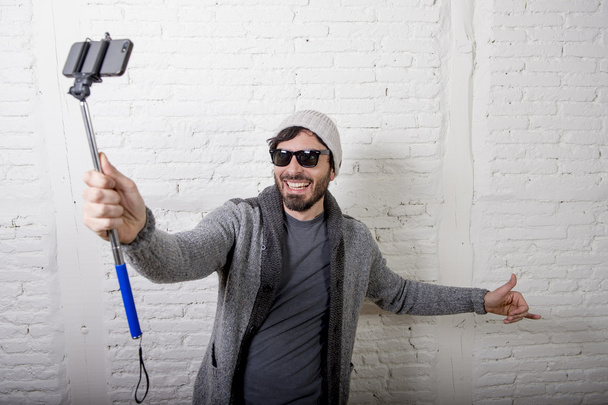 young hipster trendy blogger man holding stick recording selfie video in vlog concept - Fotoğraf, Görsel