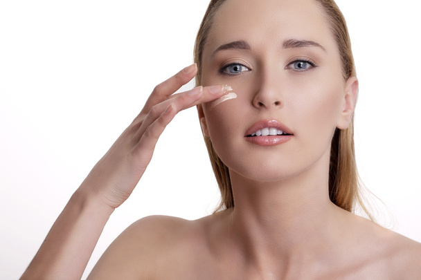 Closeup of beautiful model applying her skin treatment  - Foto, afbeelding