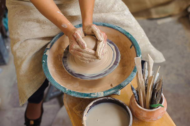 hands of a potter, creating an earthen jar on the circle - Foto, Imagem