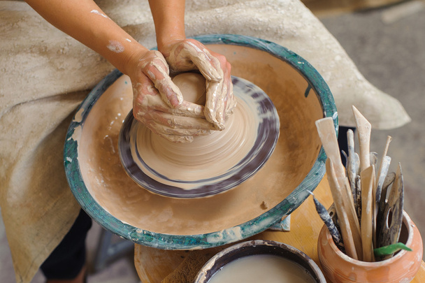 hands of a potter, creating an earthen jar on the circle - Photo, image