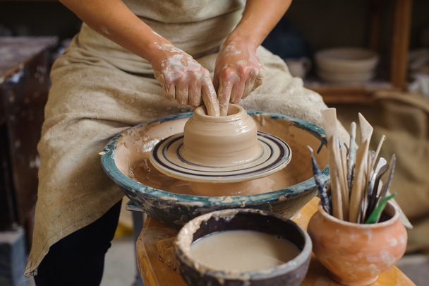 hands of a potter, creating an earthen jar on the circle - Foto, Imagem