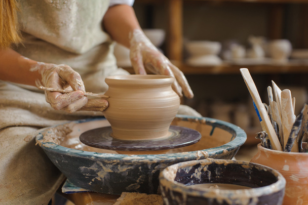hands of a potter, creating an earthen jar on the circle - Photo, Image
