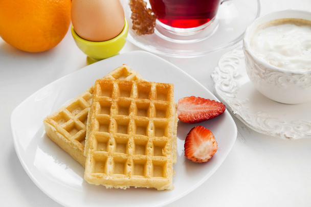 Breakfast meal with waffles and strawberries, fresh fruits , tea - Foto, imagen