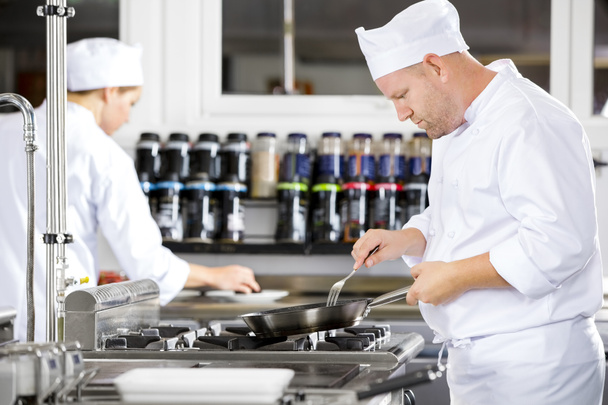Chef concentrati rendono il cibo in cucina professionale
 - Foto, immagini