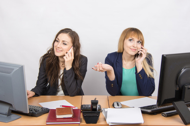 Δύο κορίτσια σε ένα γραφείο που μιλάμε στο κινητό τηλέφωνο στο γραφείο - Φωτογραφία, εικόνα