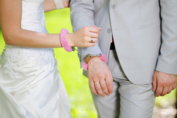 Hands of man and woman bride groom in handcuffs - Photo, Image