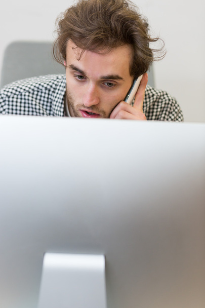 Man looking at a computer screen, thinking about the job at hand - Photo, image
