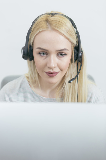 businesswoman talking on the phone while working on her computer - Valokuva, kuva