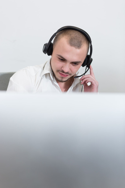 Smiling assistant using a headset in a call center - Zdjęcie, obraz