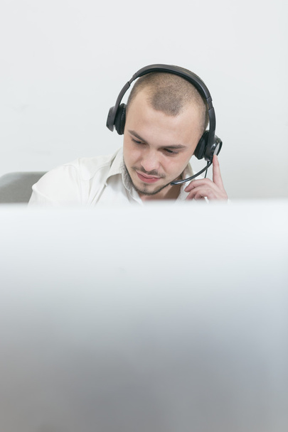 Smiling assistant using a headset in a call center - Zdjęcie, obraz