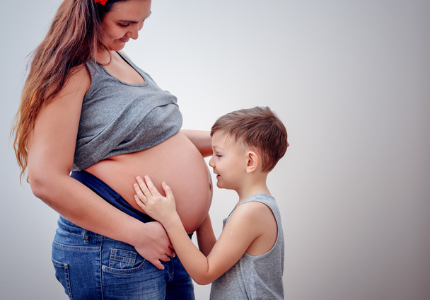 Kobieta w ciąży obok młodego dziecka - Zdjęcie, obraz