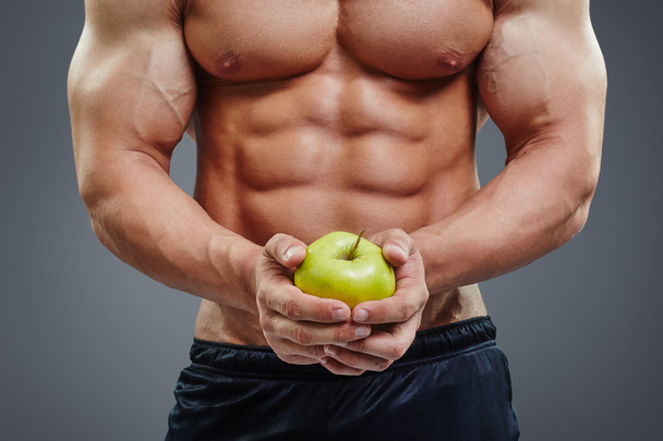 shirtless bodybuilder holding an apple - Photo, image
