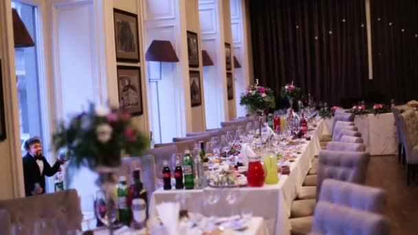 Όμορφη γαμήλια διακόσμηση από λουλούδια και διαφόρων ειδών και χρωμάτων σε ένα τραπέζι του γάμου σε ένα φανταχτερό εστιατόριο. - Πλάνα, βίντεο