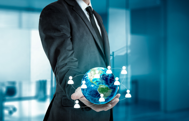 Empresario sosteniendo el globo en sus manos. El concepto de gestión de personal en todo el mundo
. - Foto, imagen
