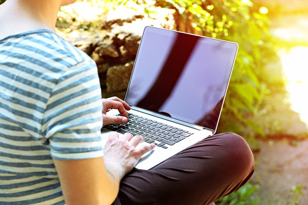 Man working with laptop in park - Photo, Image