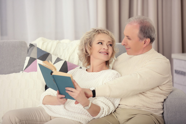 Mature couple reading book together - Foto, afbeelding