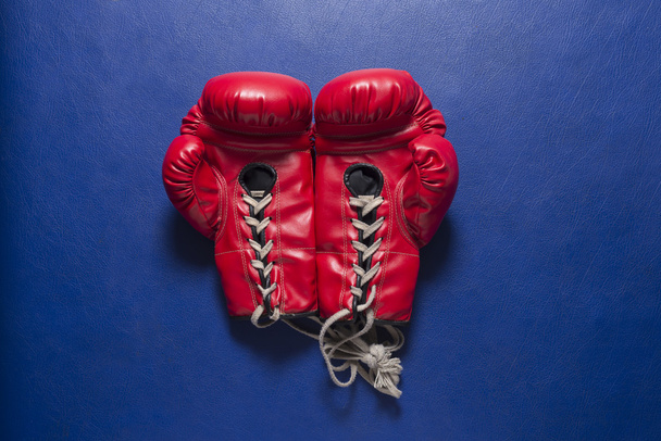 Перчатки для бокса: Красные боксерские перчатки на синем кожаном фоне - Фото, изображение