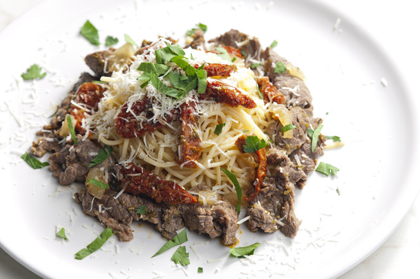 espaguetis con carne de res y tomates secos
 - Foto, imagen