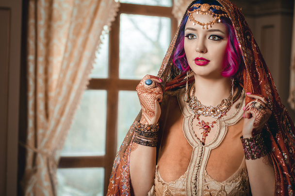 retrato de una hermosa mujer joven en vestido étnico tradicional indio y patrones nacionales pintados en las manos, mehendi
. - Foto, Imagen