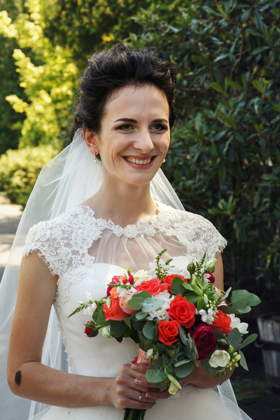 Happy smiling brunette bride with bouquet - Фото, зображення