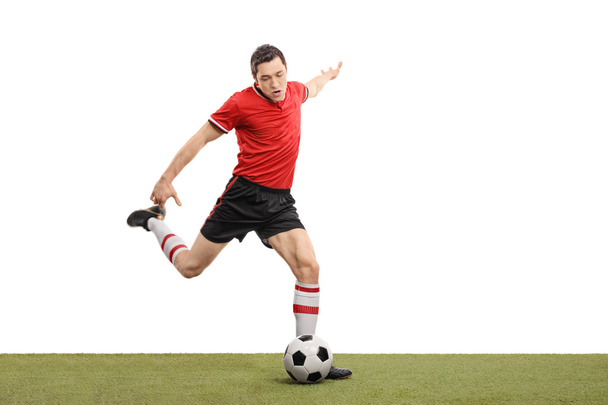 Young football player kicking a ball  - Foto, afbeelding