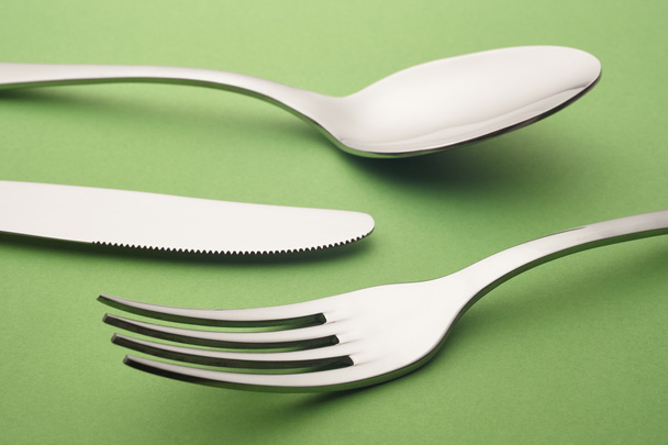 Fork knife spoon detail over a green background. Cutlery - Fotografie, Obrázek