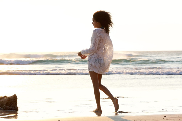 Женщина, гуляющая по пляжу - Фото, изображение