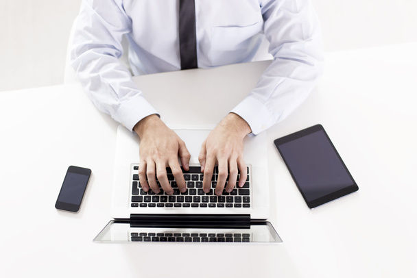 Vue d'ensemble d'un homme d'affaires utilisant son ordinateur portable
 - Photo, image