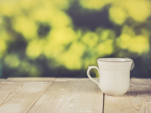 Винтажная чашка на деревянном столе; отфильтрованный винтажный цвет
 - Фото, изображение