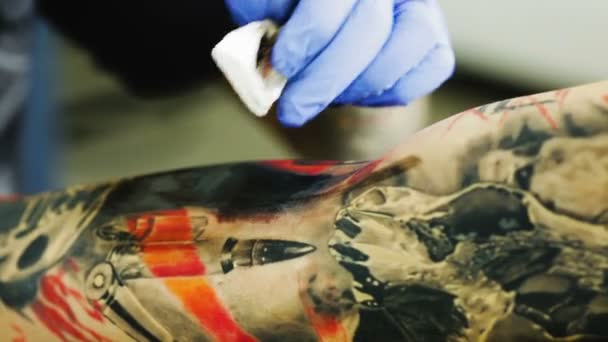 Tatuoija laittaa mustaa mustetta
 - Materiaali, video