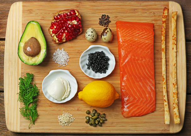 Tasty ingredients of salmon tartare on cutting board, flat lay - Foto, immagini