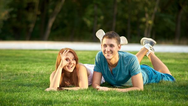 芝生の上で横になっている幸せなカップル - 写真・画像