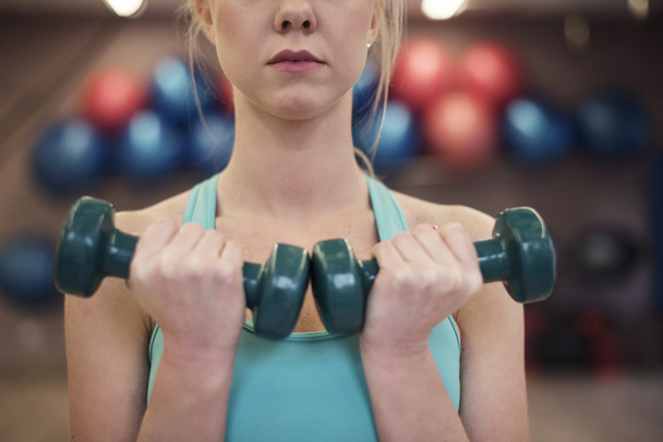 Femme utilisant des haltères à la salle de gym
 - Photo, image