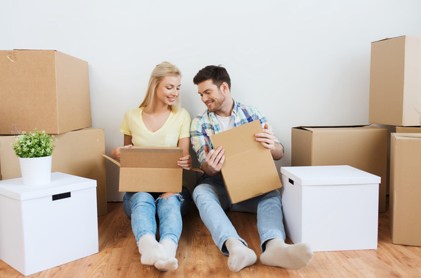 smiling couple with many boxes moving to new home - Fotoğraf, Görsel