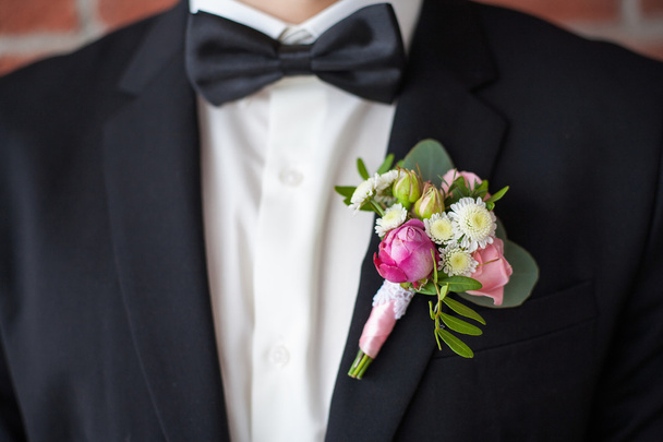 boutonniere pinned on man in black suit - Photo, Image