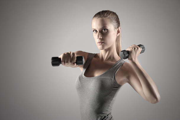 Woman lifting weights - Фото, изображение
