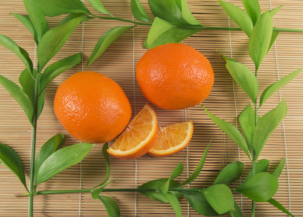 İki portakal kesilmiş dilimleri bir bambu Mat yalan ile - Fotoğraf, Görsel