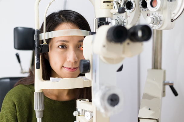 Woman checking vision at eye clinic - Foto, afbeelding