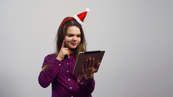 muchacha joven con sombrero de Navidad hacer compras en línea con la computadora de la tableta
 - Metraje, vídeo