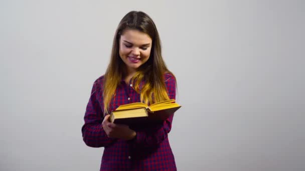 ευτυχισμένος φοιτητής κορίτσι ανάγνωση βιβλίων μπροστά από το λευκό τοίχο - Πλάνα, βίντεο