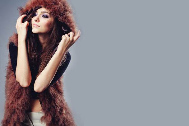Portrait of attractive stylish woman in fur against grey background. - Photo, Image