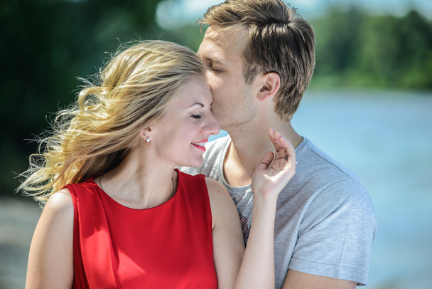 Young happy couple hugging and laughing on river background - Photo, Image