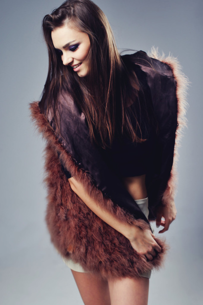 Portrait of attractive stylish woman in fur against grey background. - Foto, Imagem