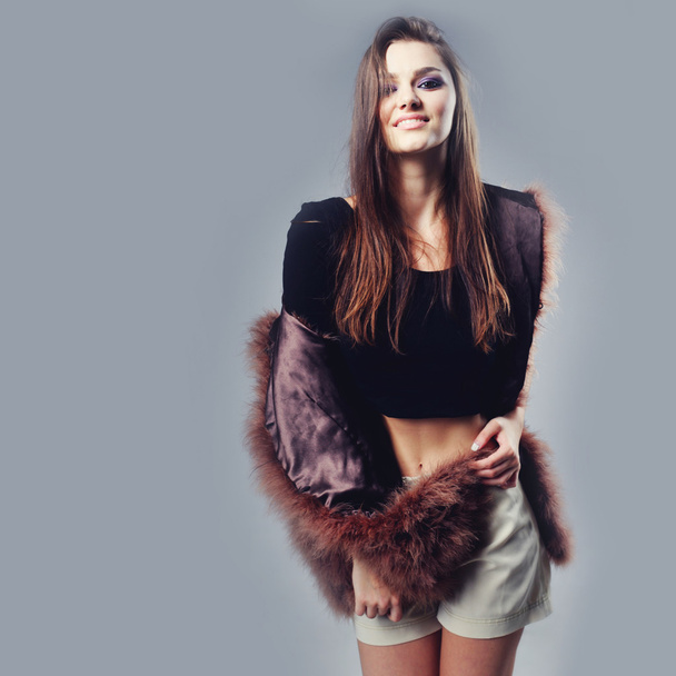 Portrait of attractive stylish woman in fur against grey background. - Foto, afbeelding