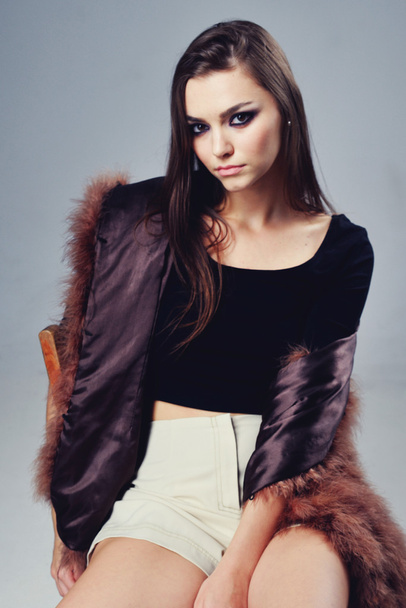 Portrait of attractive stylish woman in fur against grey background. - Foto, imagen