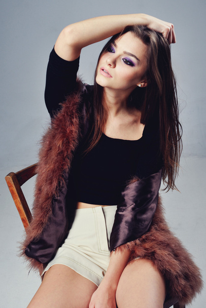 Portrait of attractive stylish woman in fur against grey background. - Photo, image