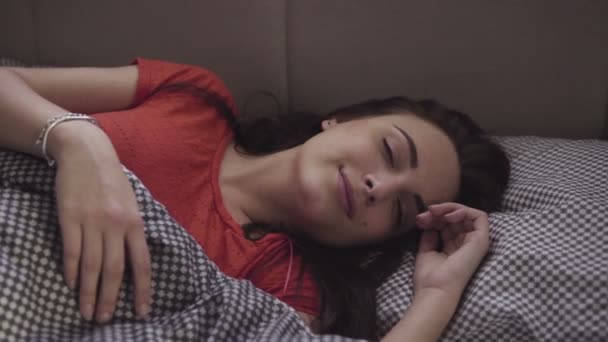 Lassított felvétel, egy csinos lány, aki a streching magát az egy ágyban alvás után. - Felvétel, videó